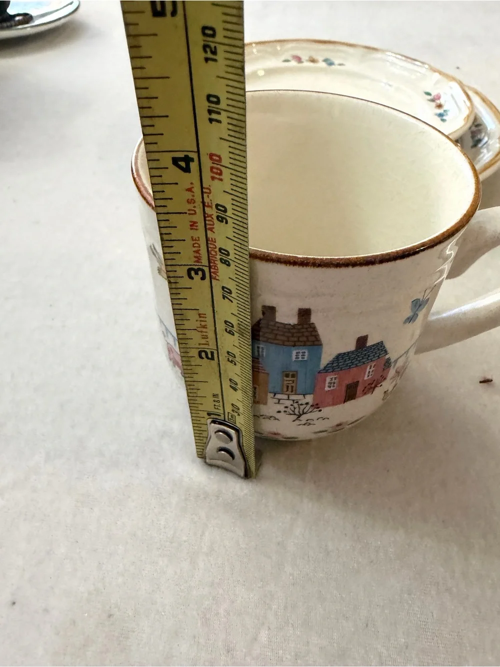 International Cream Ceramic Cup and Saucer Set with Hand-Painted Village Design